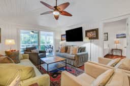 Palm-surrounded abode with screened-in balcony, chef's kitchen, smart TVs, & W/D