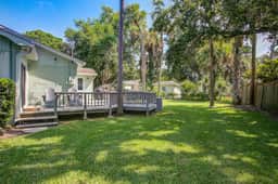 Refined coastal home surrounded by palms with large deck & athletic court access