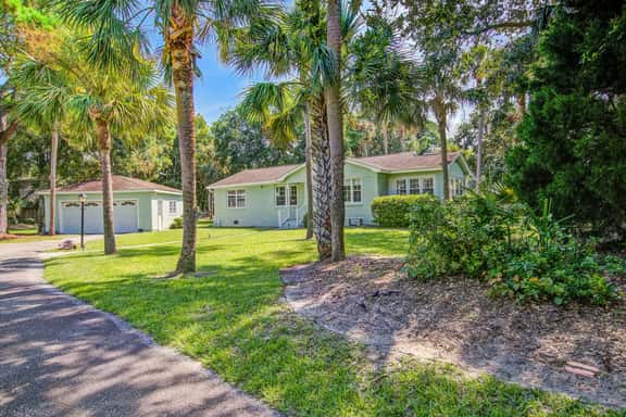 Refined coastal home surrounded by palms with large deck & athletic court access - Image 1