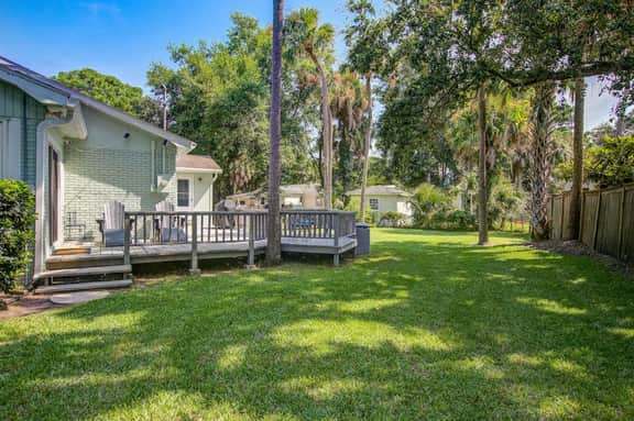 Refined coastal home surrounded by palms with large deck & athletic court access