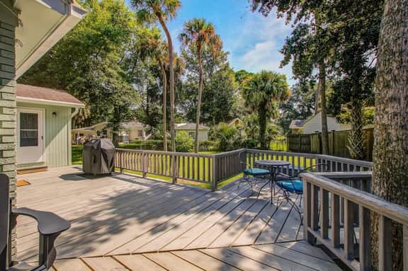 Refined coastal home surrounded by palms with large deck & athletic court access