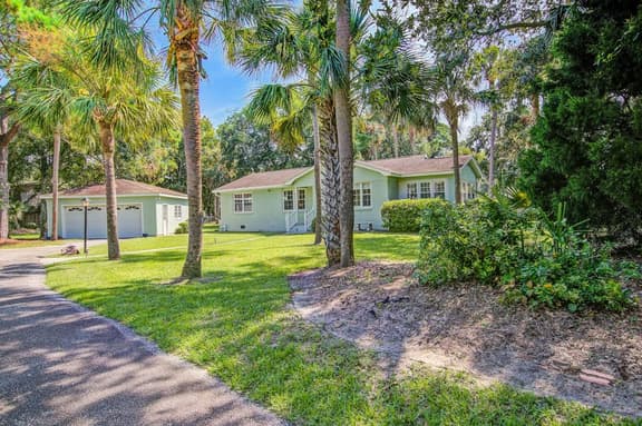 Refined coastal home surrounded by palms with large deck & athletic court access